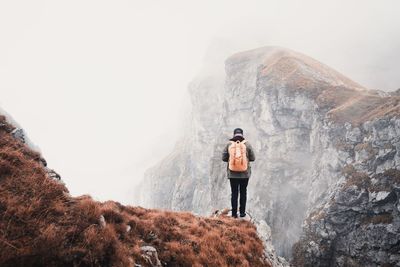 Full length of man standing on rock in mountains