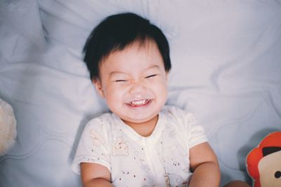 Portrait of a smiling girl lying on bed