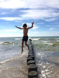Full length rear view of man standing on beach
