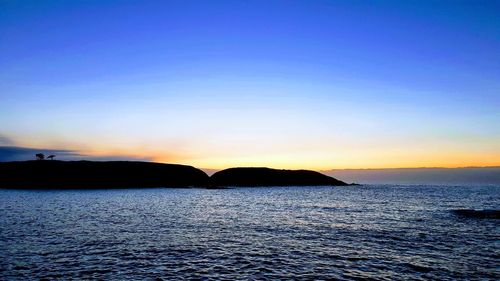 Scenic view of sea against clear sky during sunset