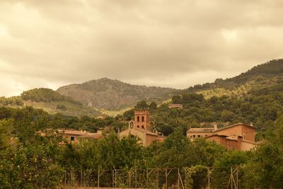 Houses on mountain against sky