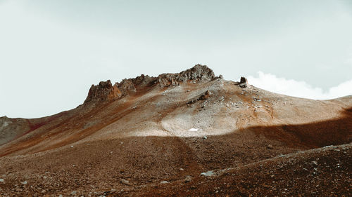 Low angle view of rock formation on land against sky