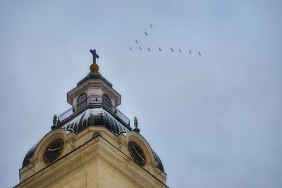 Low angle view of birds flying against sky