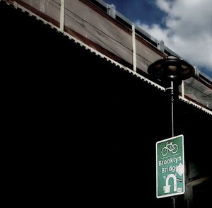 Low angle view of information sign against sky