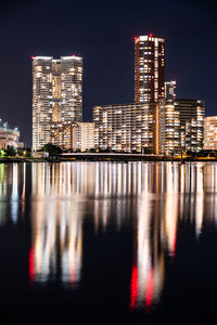 Reflection of illuminated buildings in sea at night