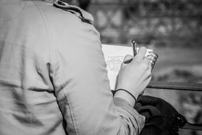 Midsection of woman drawing in book