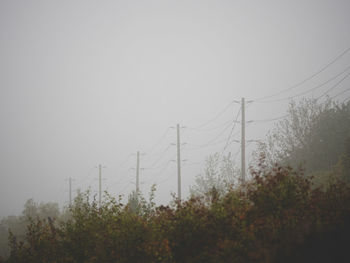 Low angle view of electricity pylon against clear sky