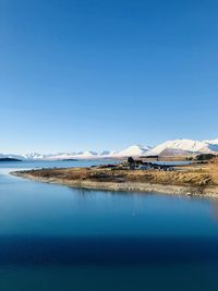 Scenic view of lake against clear blue sky