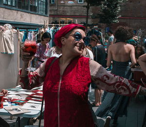 Smiling woman holding drink at market