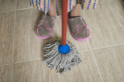 Feet of senior woman with cleaning mop