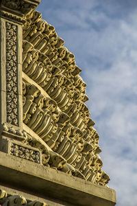 Low angle view of sculpture of building against cloudy sky