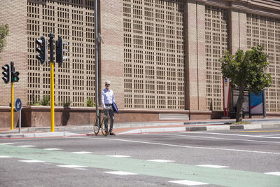 Mature man waiting at crossing with his bicycle