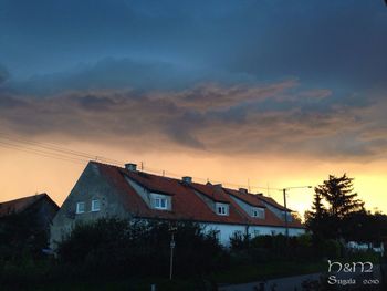 Houses against sky during sunset