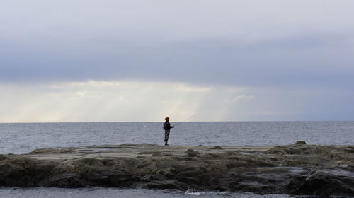 Man standing on beach against sky