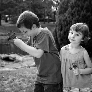 Portrait of girl standing with brother at park