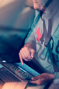 Midsection of computer programmer using digital tablet in car