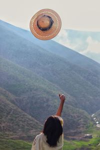 Rear view of woman standing on mountain