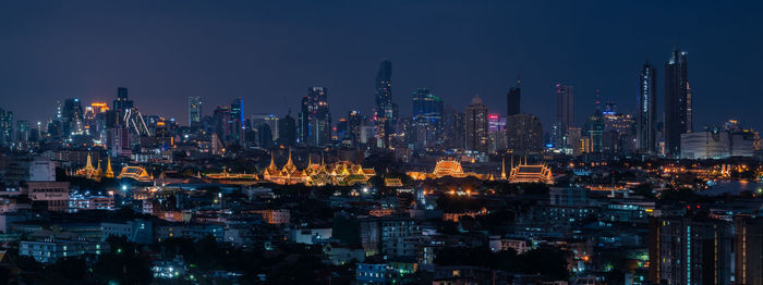 Illuminated buildings in city against sky at night