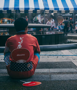 Rear view of man sitting in city