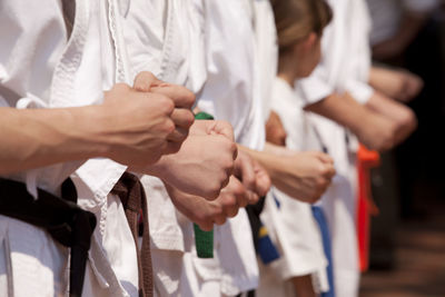 Midsection of people performing karate