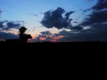 Low angle view of silhouette landscape against dramatic sky