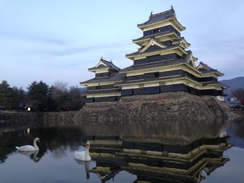 Historic building by lake against sky