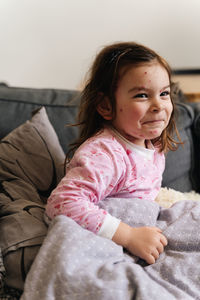 Cute girl sitting on bed at home