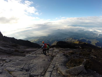 Man skiing on mountain against sky