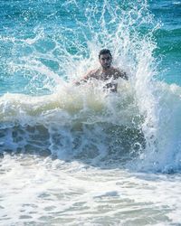 Wave splashing on man in sea