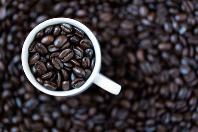 Close-up of roasted coffee beans with cup