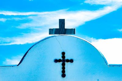 Low angle view of cross on building against sky