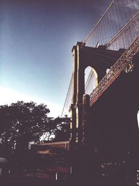 Low angle view of suspension bridge against sky