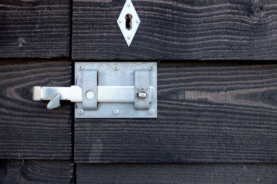 Close-up of metallic latch on wooden door