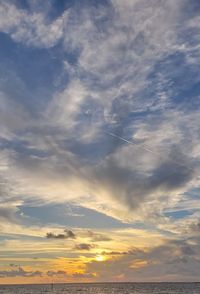 Low angle view of vapor trail in sky during sunset