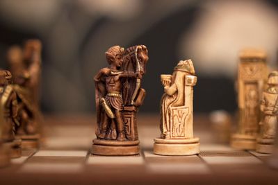 Close-up of antique chess pieces on board
