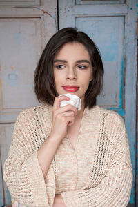 Smiling woman standing against wall