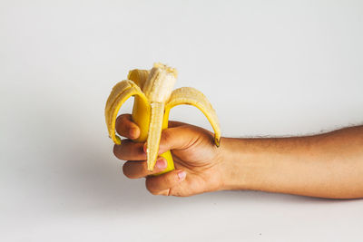 Midsection of person holding apple against white background