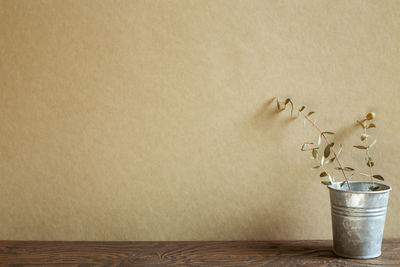 Close-up of vase on table against wall at home