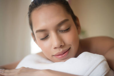 Close-up of smiling young woman lying on massage table in spa