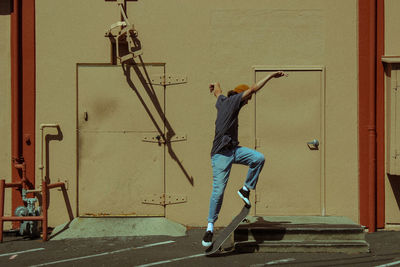 Rear view of man skateboarding on wall