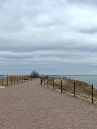 Road leading towards sea against sky