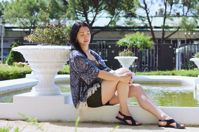 Portrait of young woman sitting in park