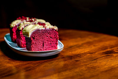 Slices of red velvet cake in a plate on wooden table