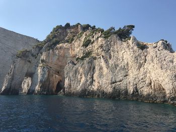 Scenic view of sea and mountains against clear sky