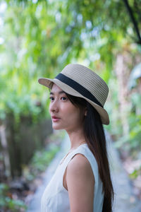 Young woman looking away while standing outdoors