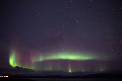 Scenic view of aurora borealis and star field at night