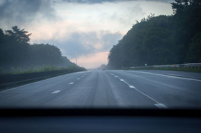 Empty road against sky seen through car windshield