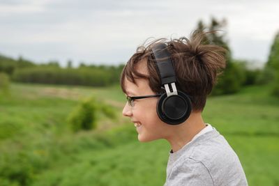 Portrait of kid listening music on field