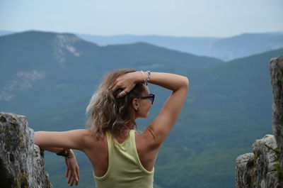 Woman standing on mountain against sky