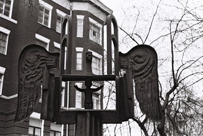 Low angle view of statue against bare trees